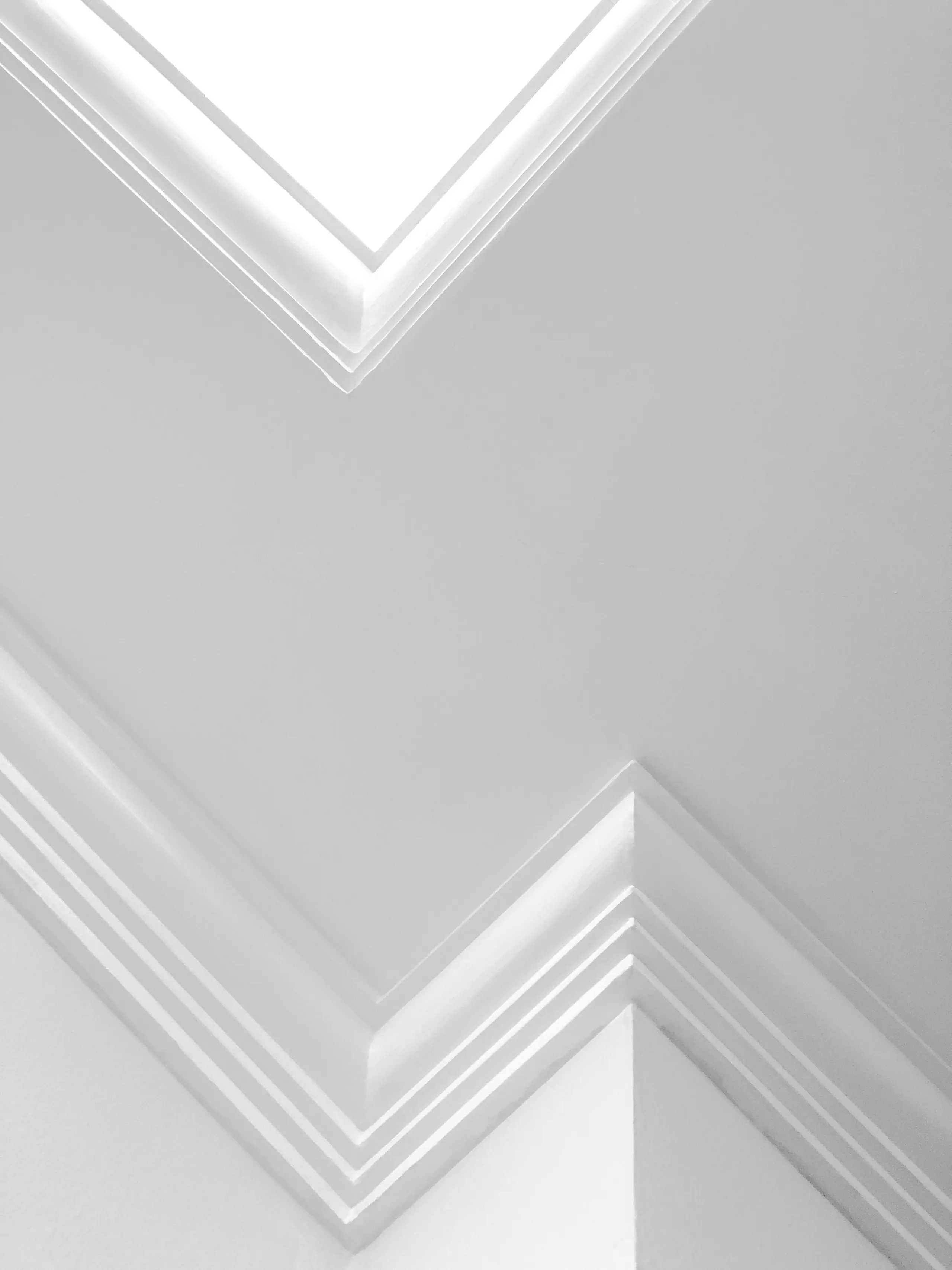 Close view of a stepped plaster cornice where two walls meet the ceiling