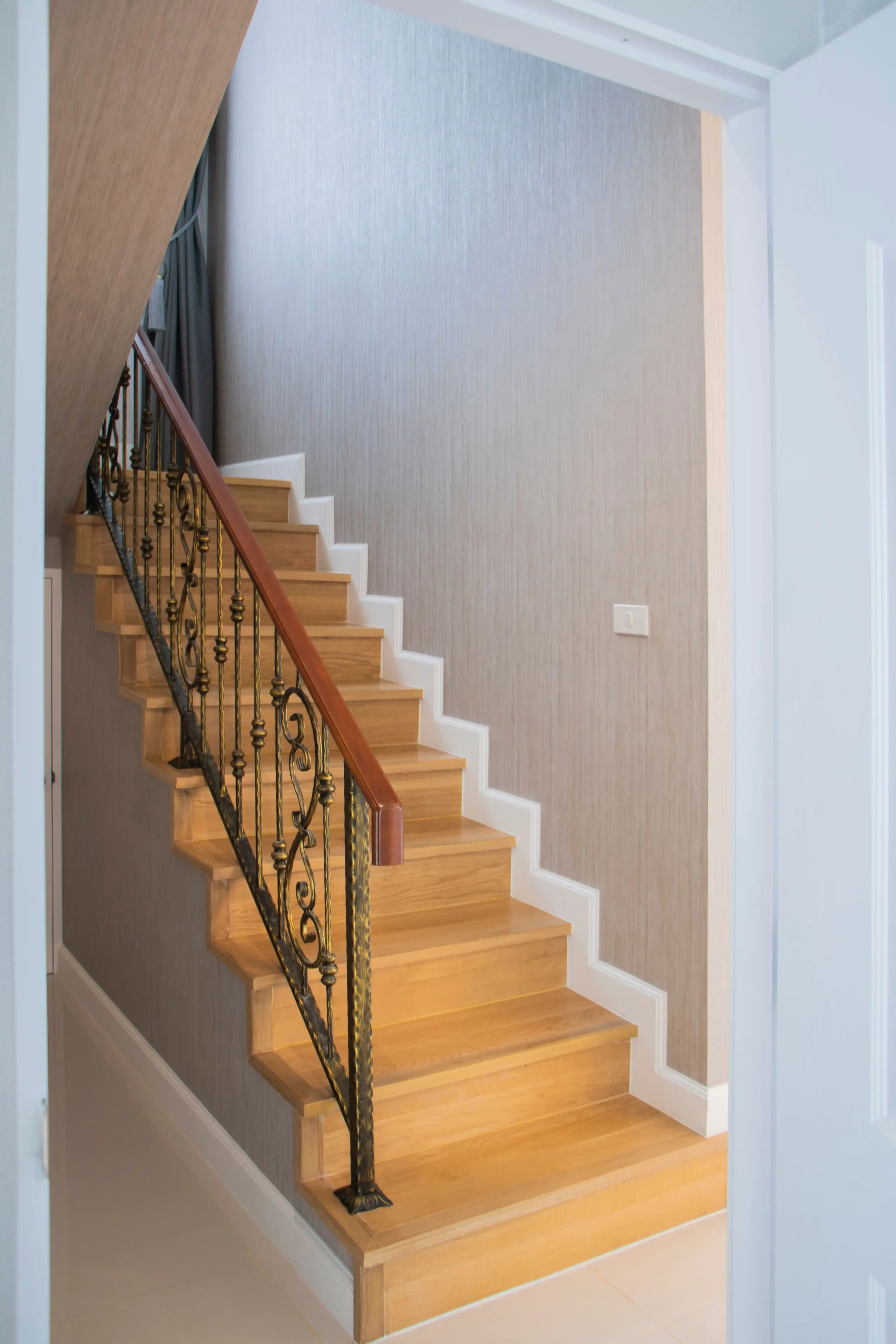 Oak stair treads with a wrought-iron balustrade and a timber handrail
